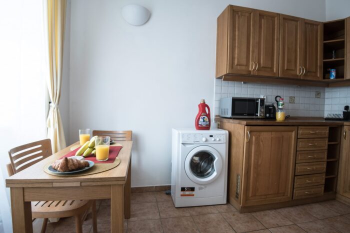 Kitchen with dining table, washing machine and a microwave