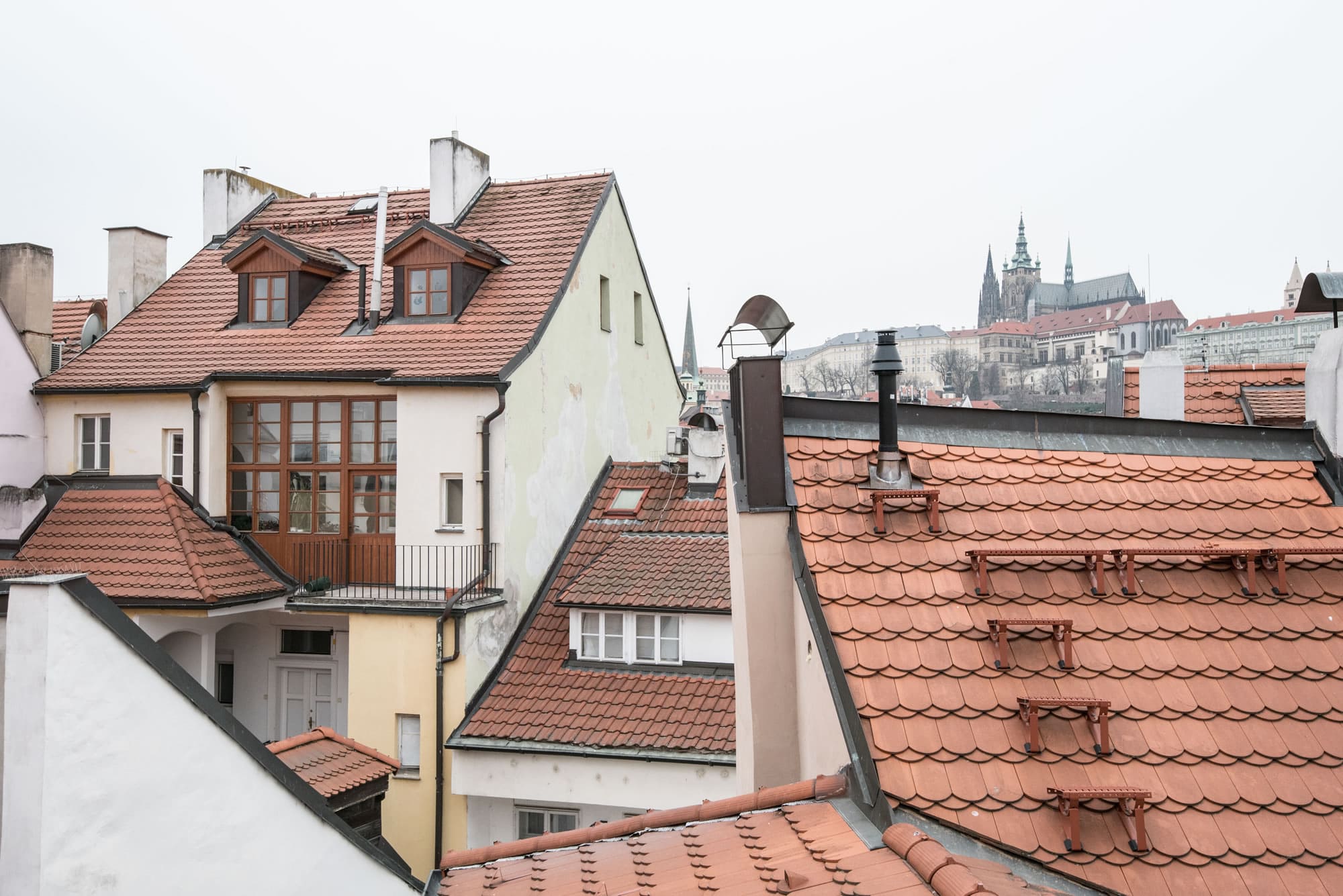 View from the apartment on red roofs. Prague castle on the above them.